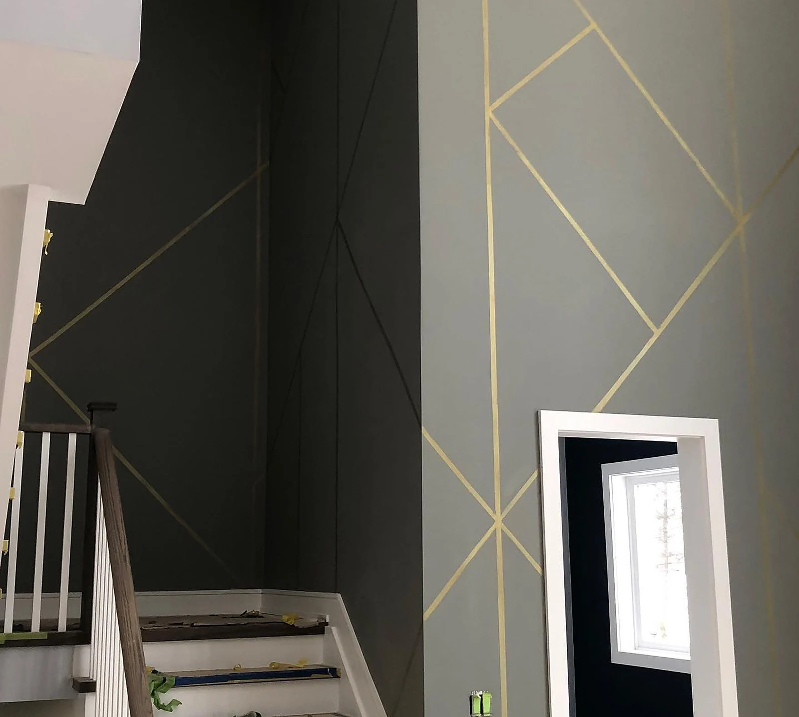 AFTER: dark charcoal stairwell wall with gold geometric triangle lines