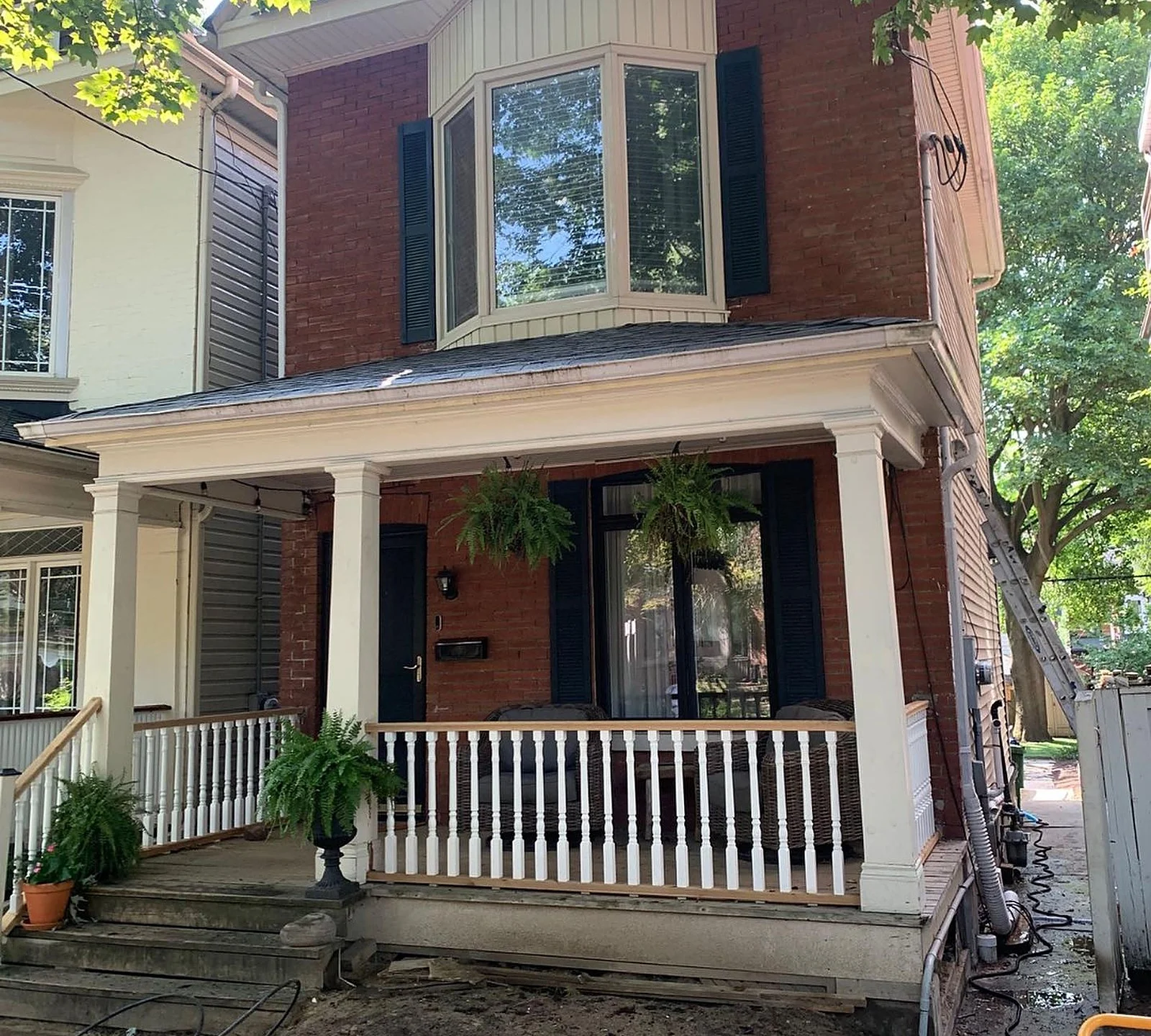 BEFORE: Riverdale red-brick house with cream porch and trim