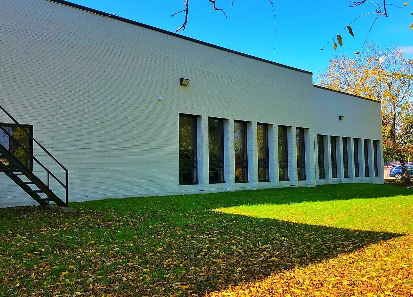 AFTER: commercial industrial building painted white, autumn lawn (MCF watermark)