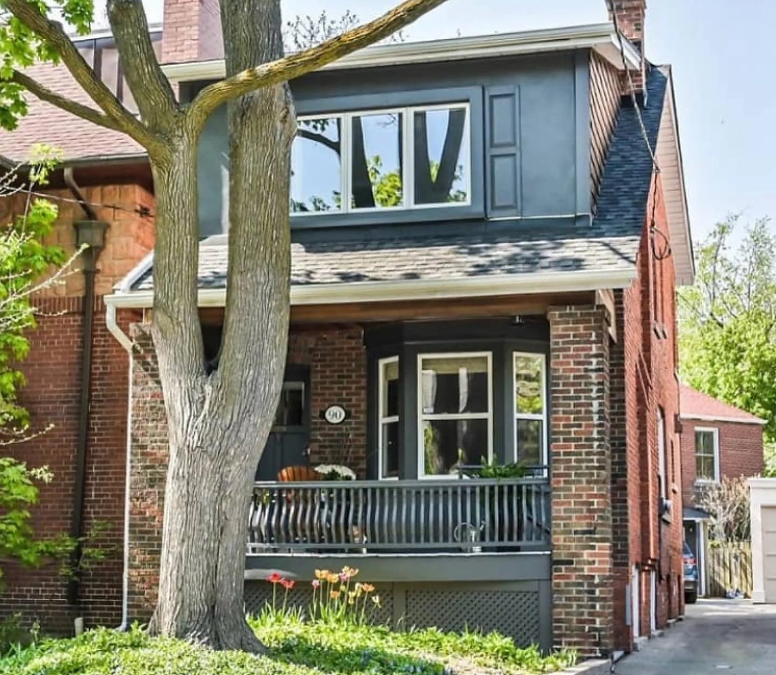 Midtown brick house exterior, upper gable and porch painted dark slate blue-grey