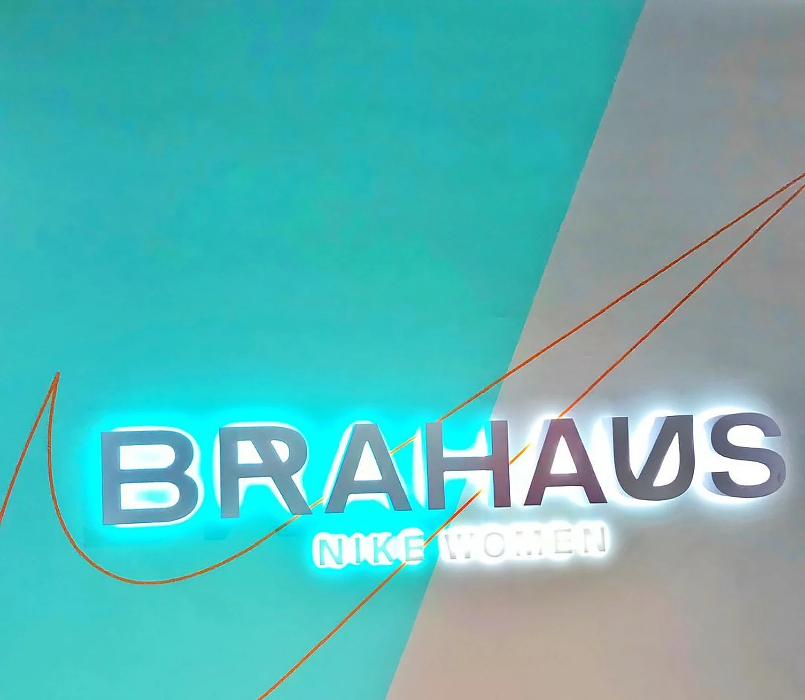 Finished teal geometric wall with lit BRAHAUS sign, Nike Eaton Centre