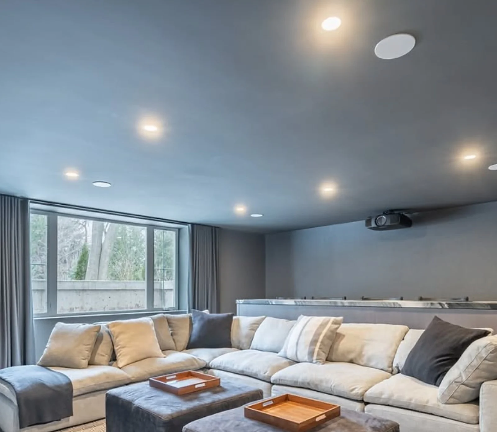 Same media room, grey-blue walls, sectional