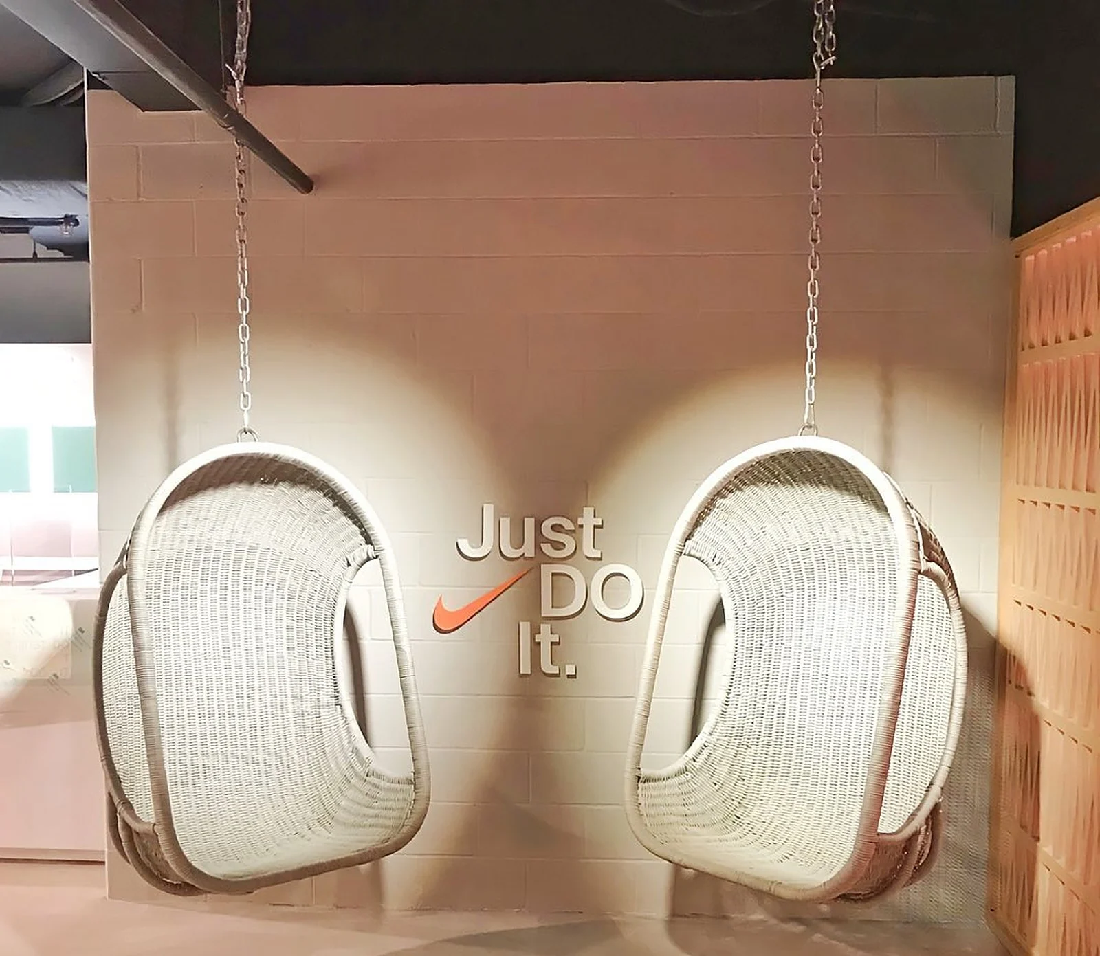 Nike "Just Do It" wall with hanging rattan chairs