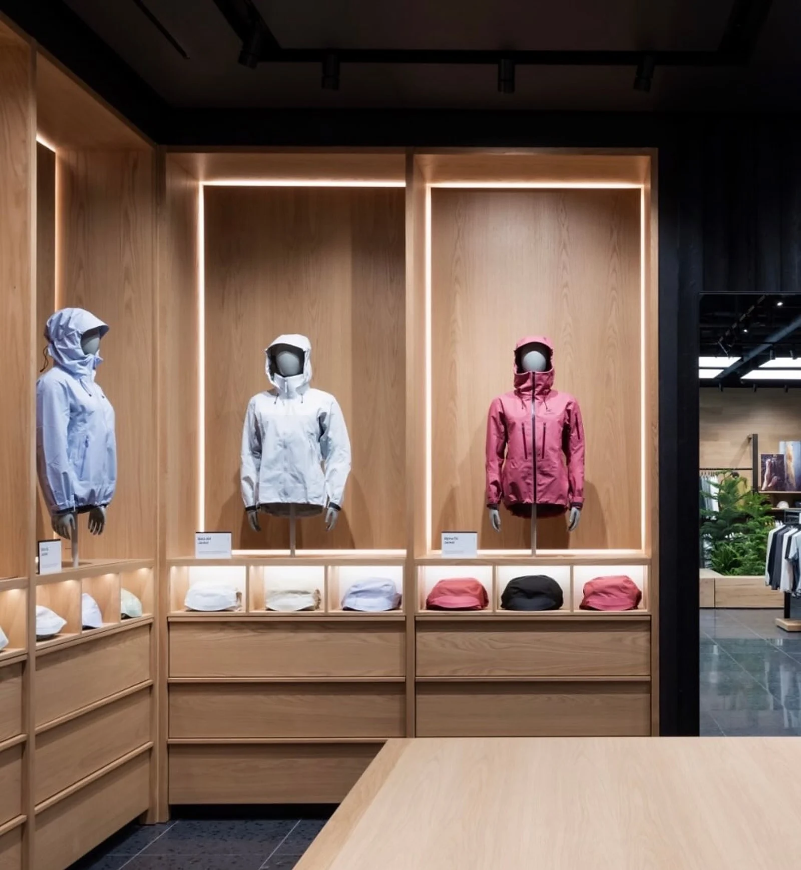 Arc’teryx display wall with lit oak bays and jackets at CF Markville