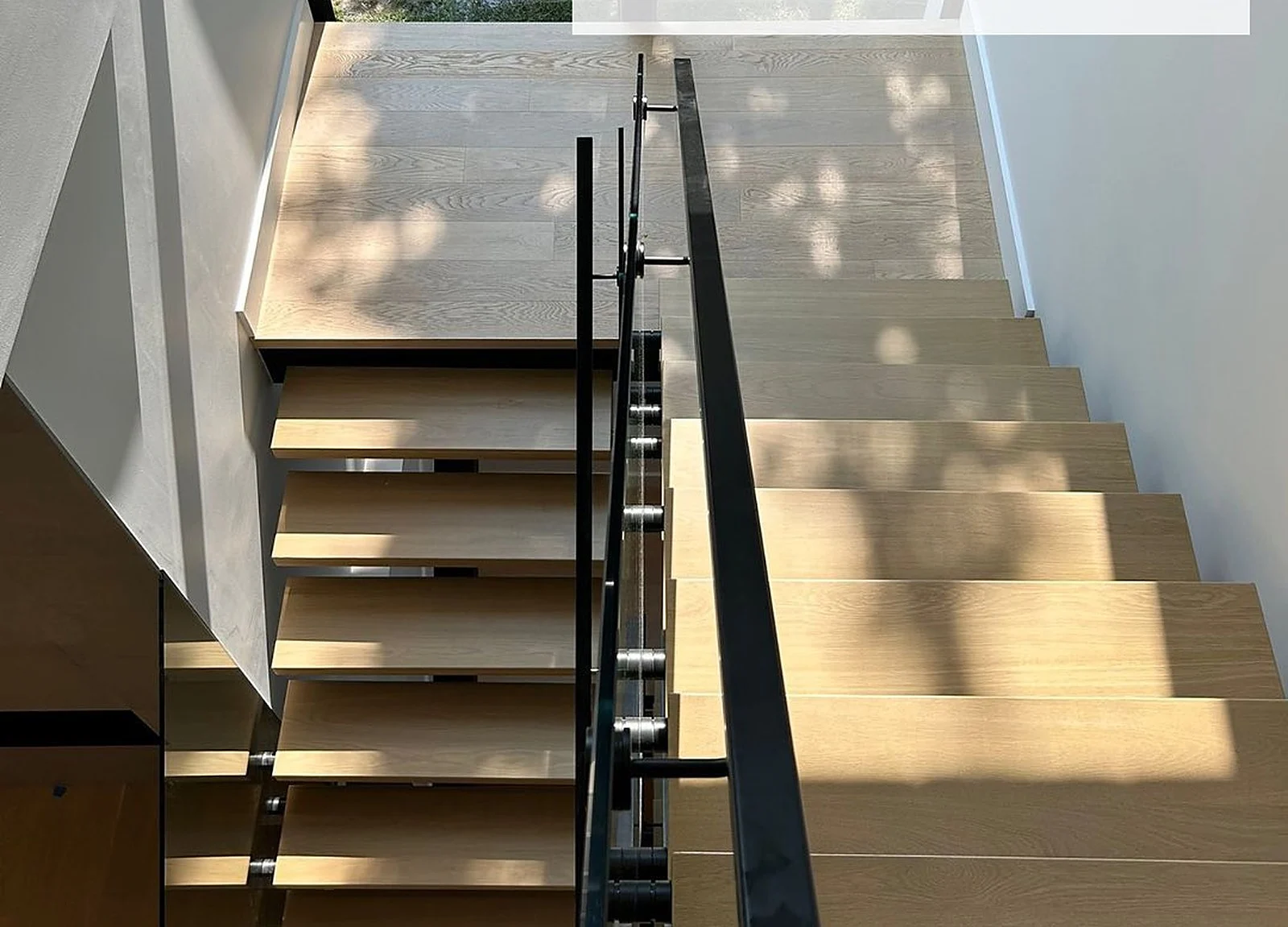 AFTER: finished light oak stairs with black metal railing