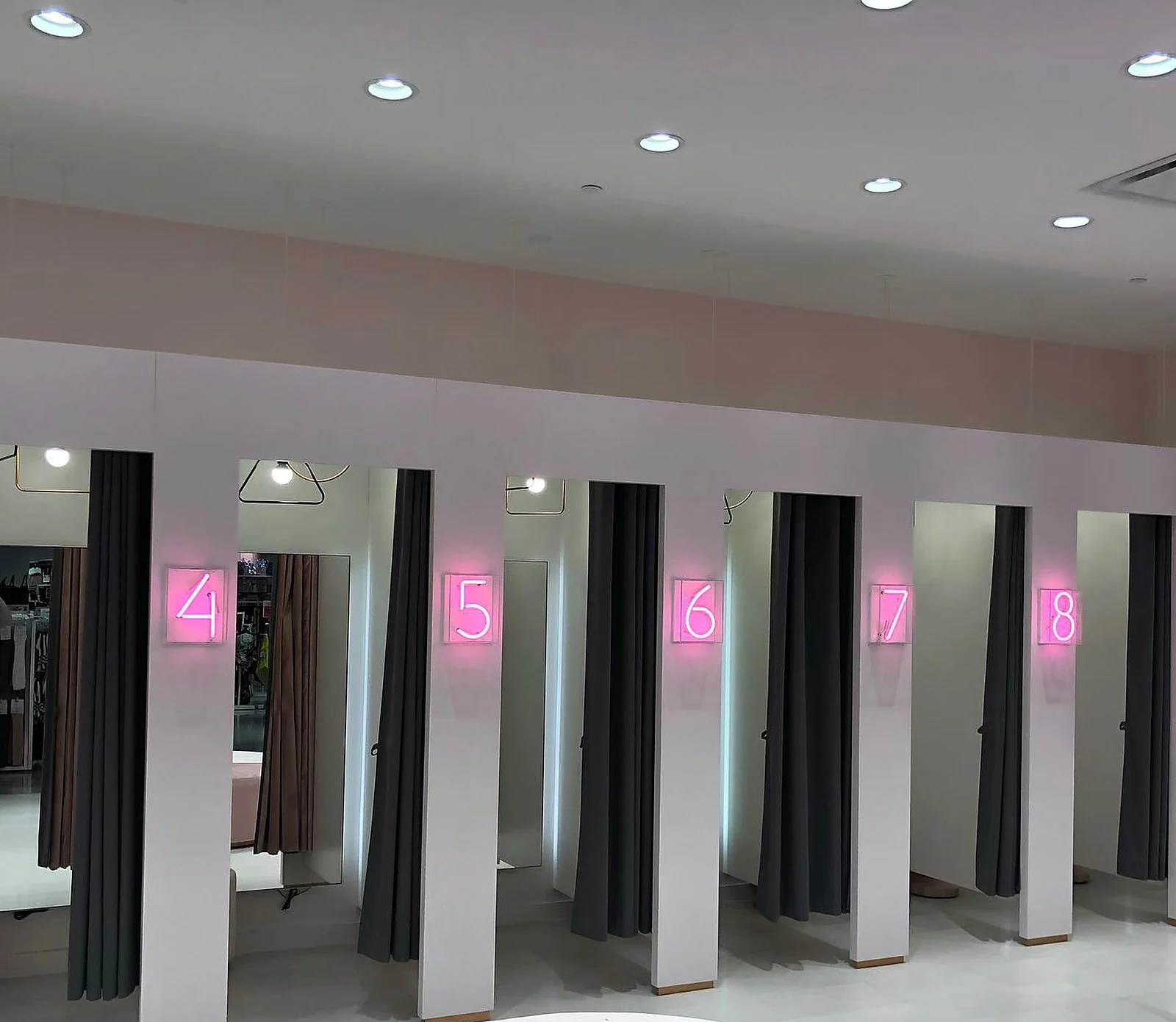 Ardene fitting rooms with neon numbers, pink wall