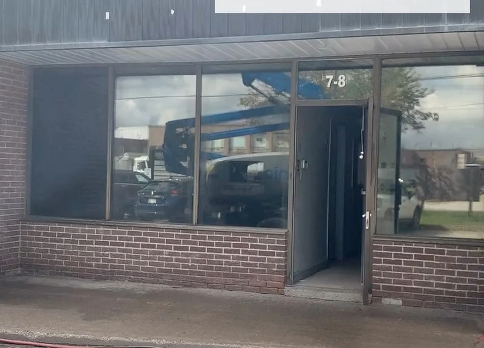 BEFORE: brown brick storefront with old windows