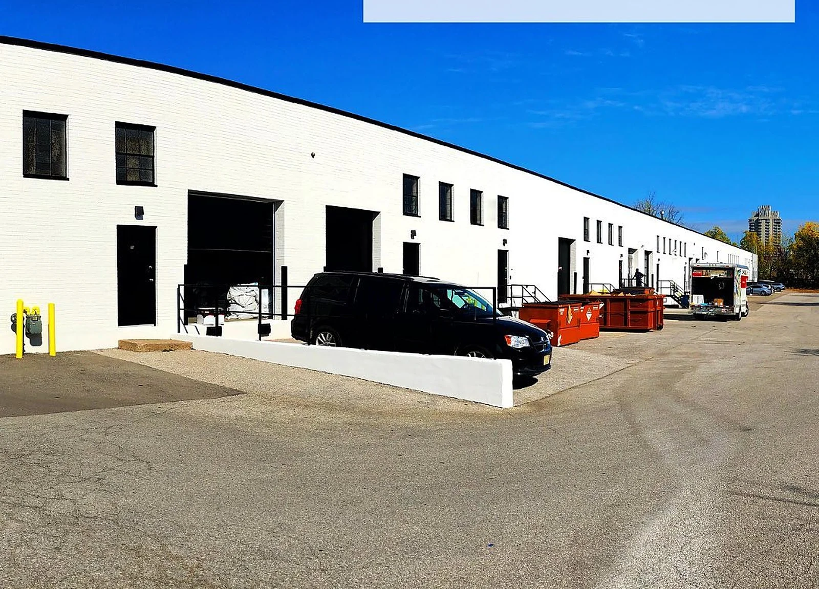 AFTER: loading-dock row painted bright white with black doors