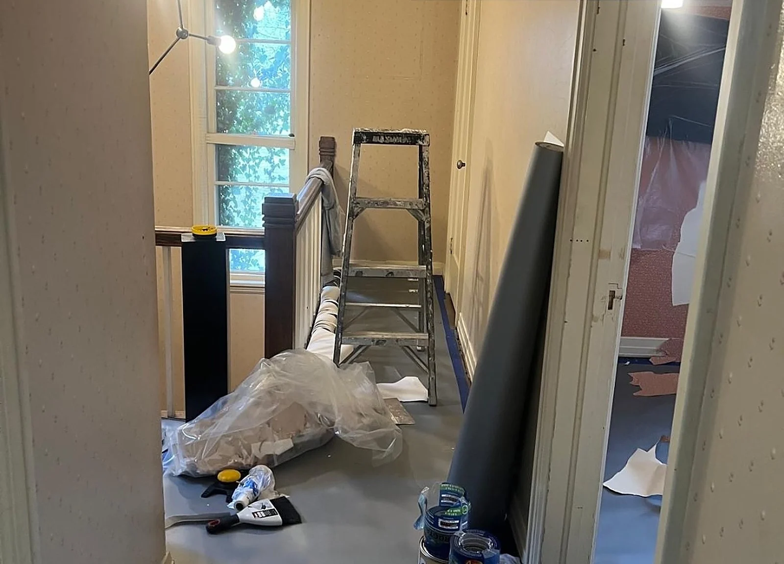 BEFORE: hallway mid-wallpaper removal, ladder