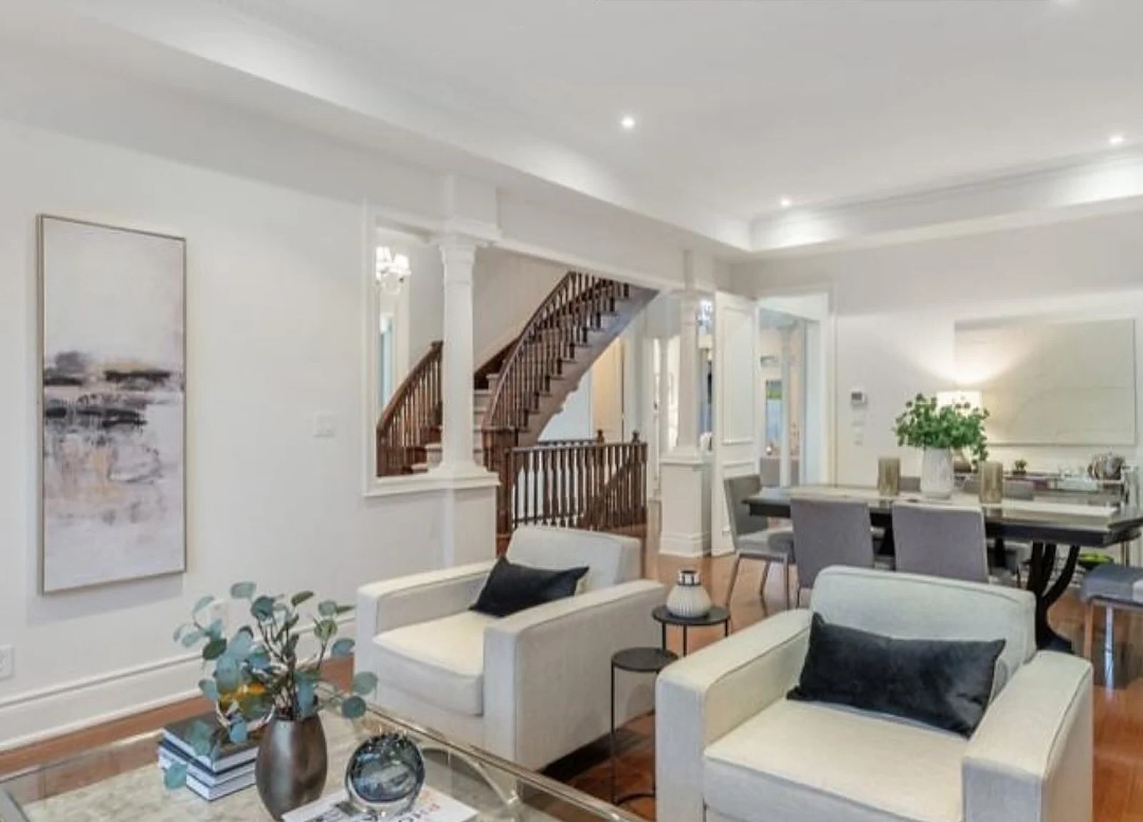 AFTER: white living room with curved staircase behind