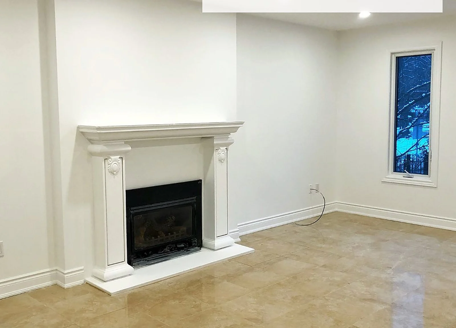 AFTER: same living room, fireplace mantel and walls painted white