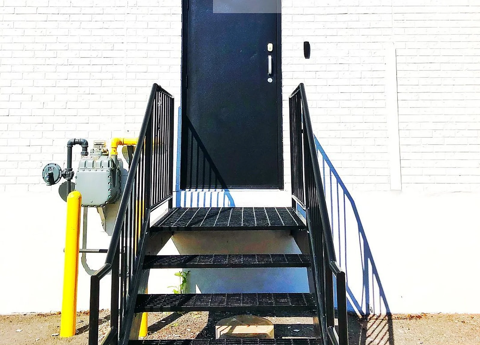 AFTER: stairs painted black, white wall, black door