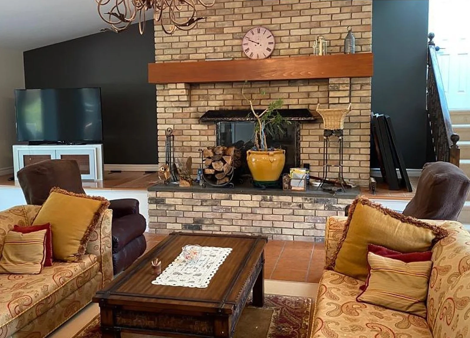 AFTER: cottage living room with brick fireplace, black accent wall