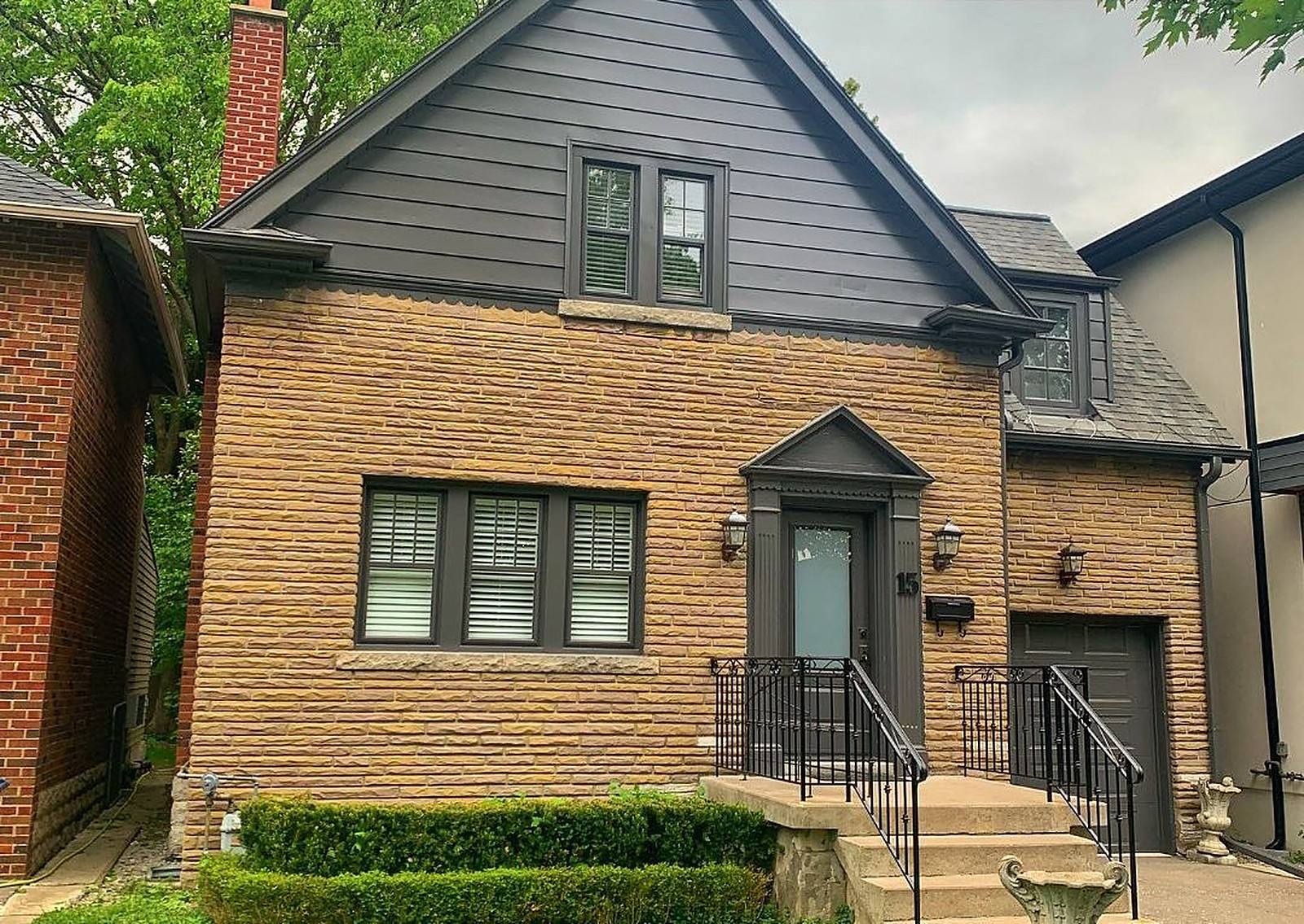 Forest Hill home with charcoal siding and stone after an exterior repaint