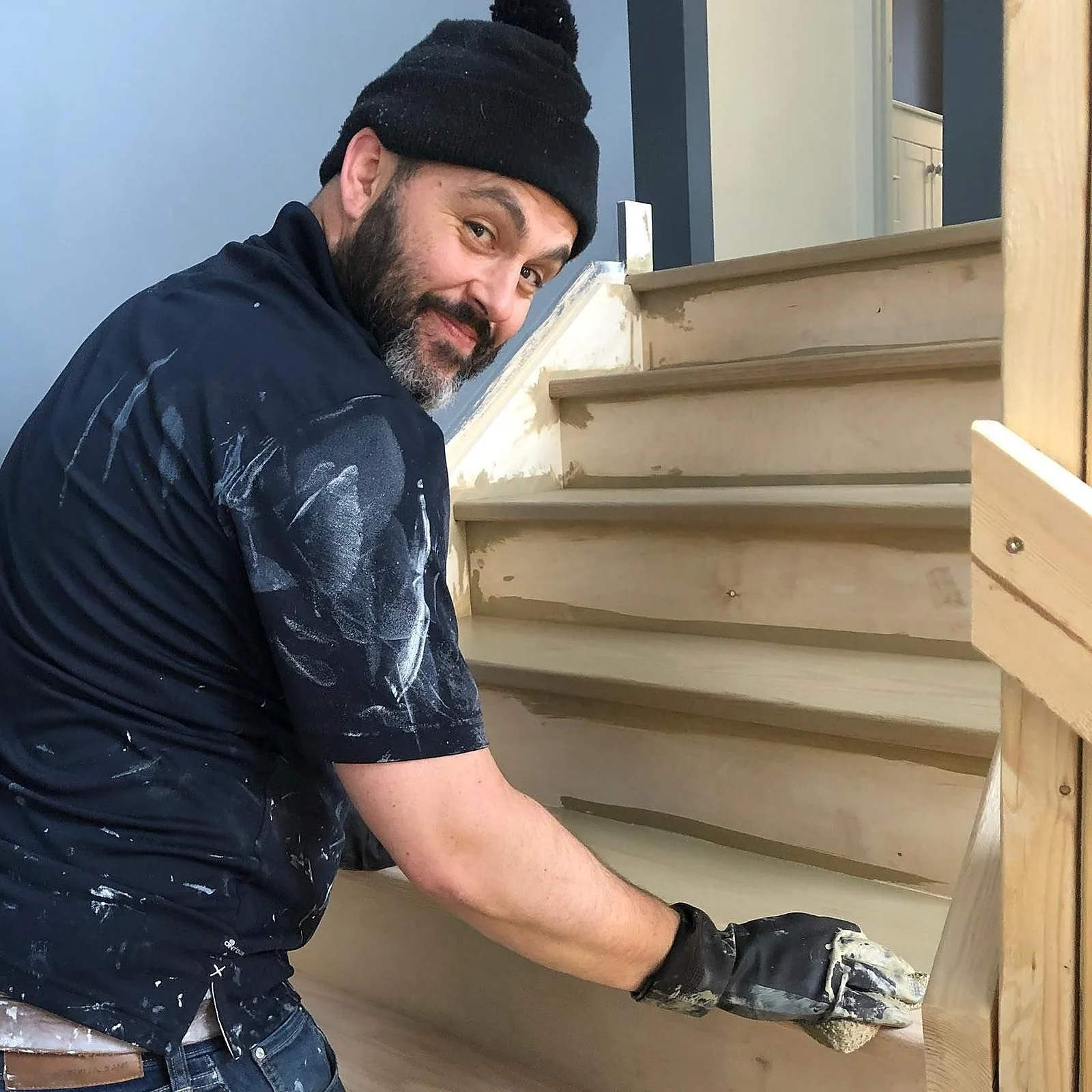 Sanding a raw wood staircase by hand